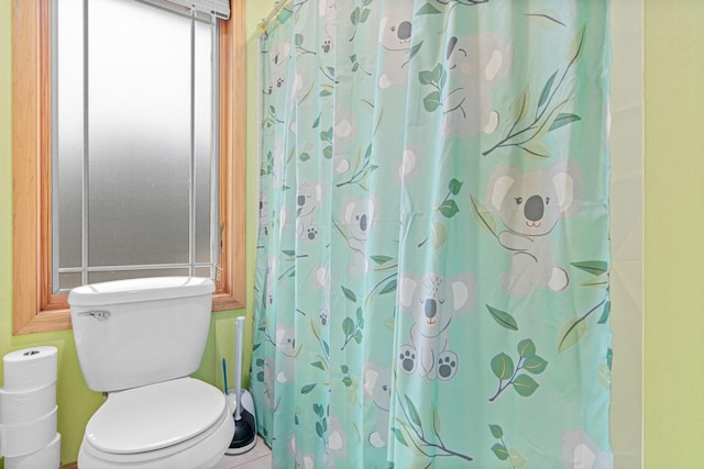 bathroom featuring a shower with shower curtain and toilet