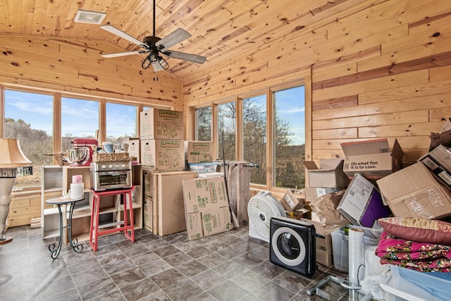 interior space with wooden walls, vaulted ceiling, ceiling fan, and wooden ceiling