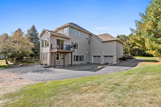 rear view of house featuring a yard and a garage