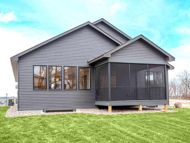 rear view of house featuring a sunroom, a lawn, and central air condition unit