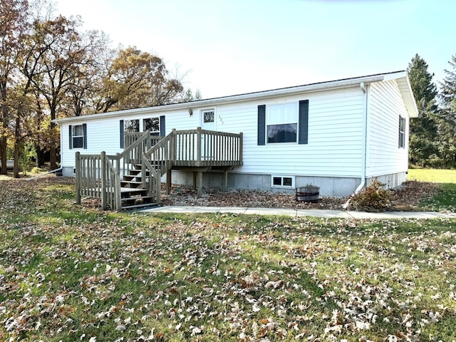 rear view of property with a yard and a wooden deck