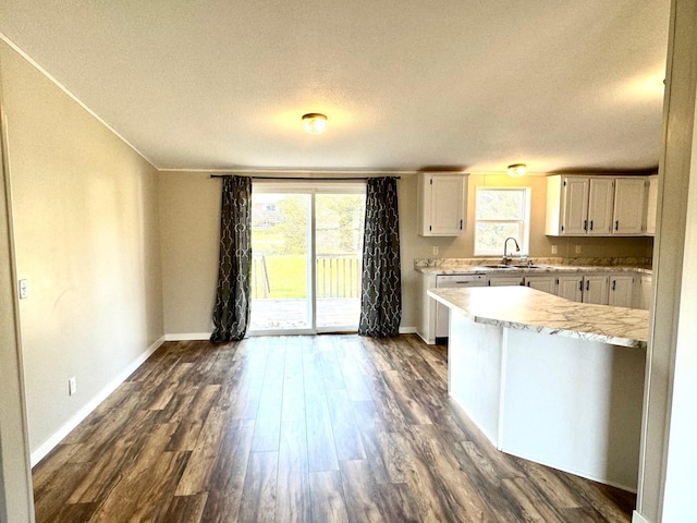 kitchen featuring a textured ceiling, white cabinetry, dark hardwood / wood-style floors, and plenty of natural light