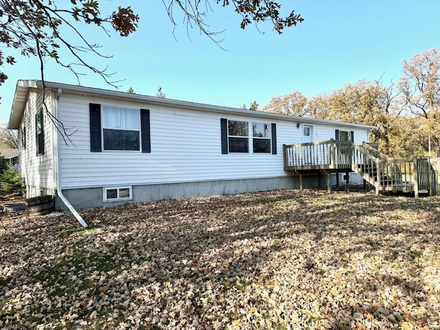 rear view of house featuring a wooden deck