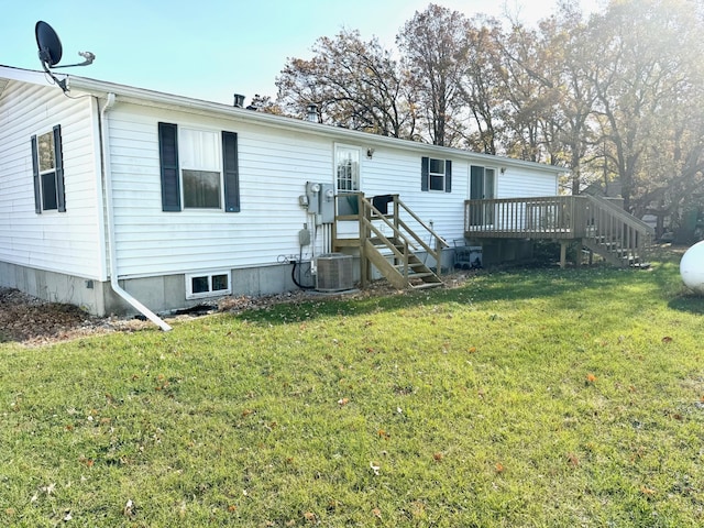 rear view of house featuring a wooden deck, a yard, and central air condition unit