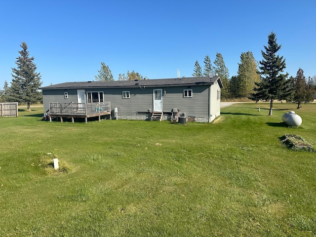 rear view of house with a wooden deck and a lawn