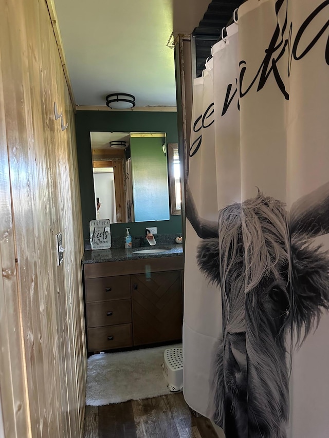 bathroom featuring vanity, crown molding, and wood-type flooring