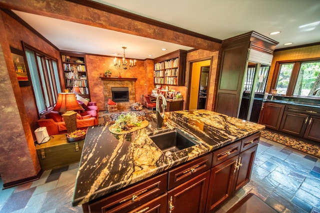 1425 20th St SW, Rochester, MN 55902 - kitchen featuring crown molding, a fireplace with raised hearth, stone counters, a chandelier, and decorative light fixtures