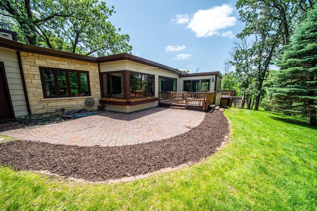 1425 20th St SW, Rochester, MN 55902 - back of house with stone siding, a yard, a patio, and a deck