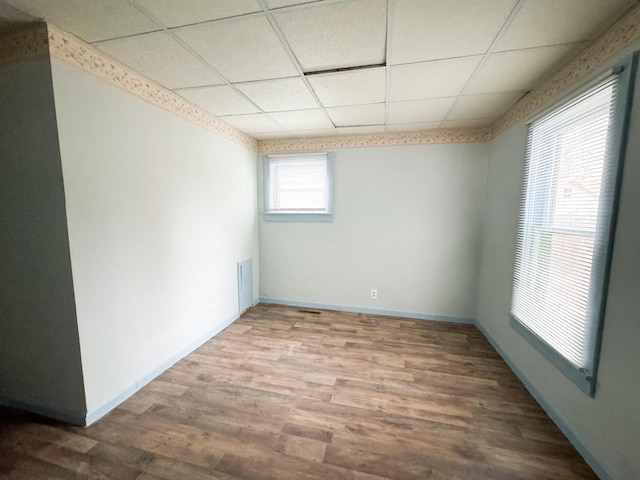 spare room featuring a drop ceiling and hardwood / wood-style floors
