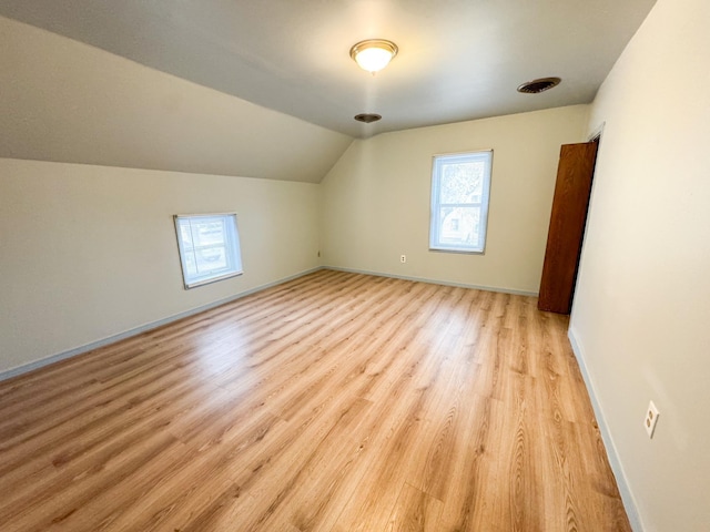 bonus room featuring lofted ceiling and light hardwood / wood-style flooring