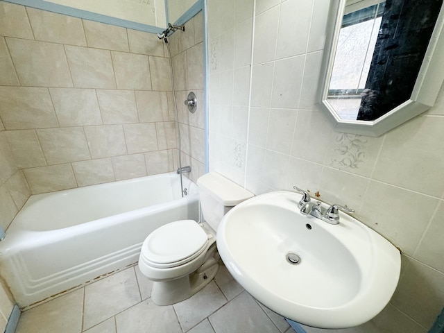 full bathroom featuring toilet, tile walls, sink, and tiled shower / bath