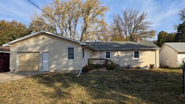 back of house with a wooden deck, a garage, and a lawn