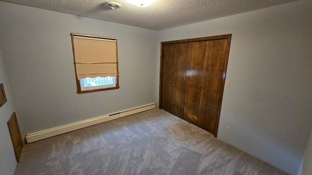 unfurnished bedroom with a baseboard radiator, a textured ceiling, a closet, and carpet flooring