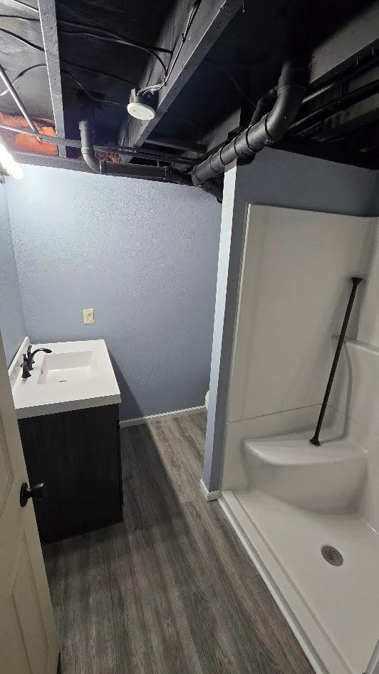 bathroom with vanity, hardwood / wood-style flooring, toilet, and walk in shower