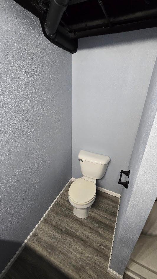 bathroom featuring toilet and wood-type flooring