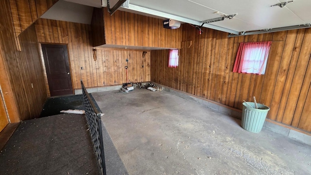 garage with wood walls and a garage door opener