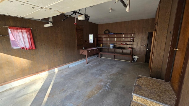 garage featuring a garage door opener and wood walls