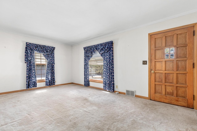 empty room with light carpet, crown molding, and a wealth of natural light