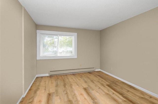 empty room featuring light hardwood / wood-style flooring and a baseboard radiator