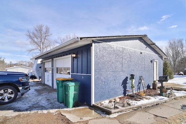 view of side of home with a garage and stucco siding