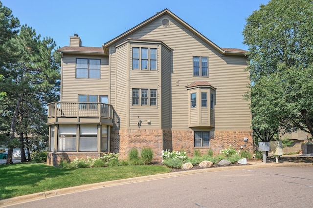 view of front of house featuring a front yard and a balcony