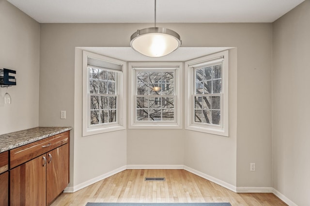 unfurnished dining area featuring light wood-type flooring