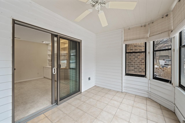 unfurnished sunroom featuring ceiling fan