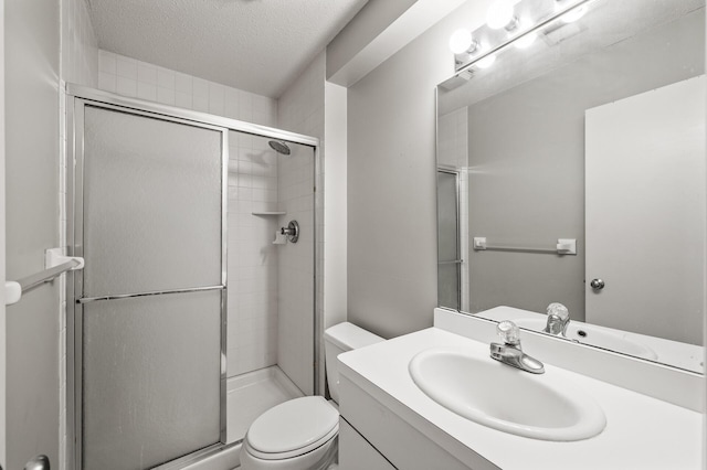 bathroom featuring vanity, an enclosed shower, a textured ceiling, and toilet