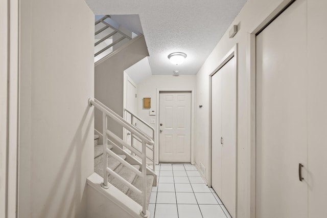 interior space featuring a textured ceiling and light tile patterned floors