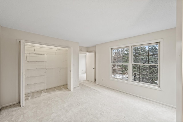 unfurnished bedroom with light carpet, a closet, and a textured ceiling