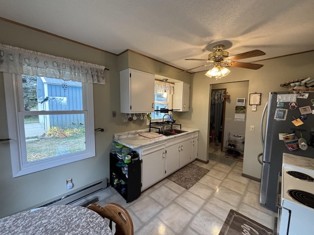 kitchen with sink, white cabinetry, stainless steel refrigerator, and ceiling fan