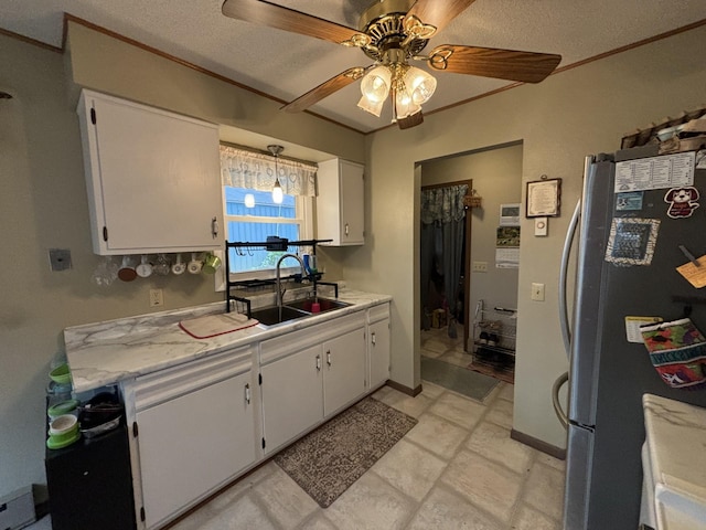 kitchen featuring white cabinetry, ceiling fan, and stainless steel refrigerator