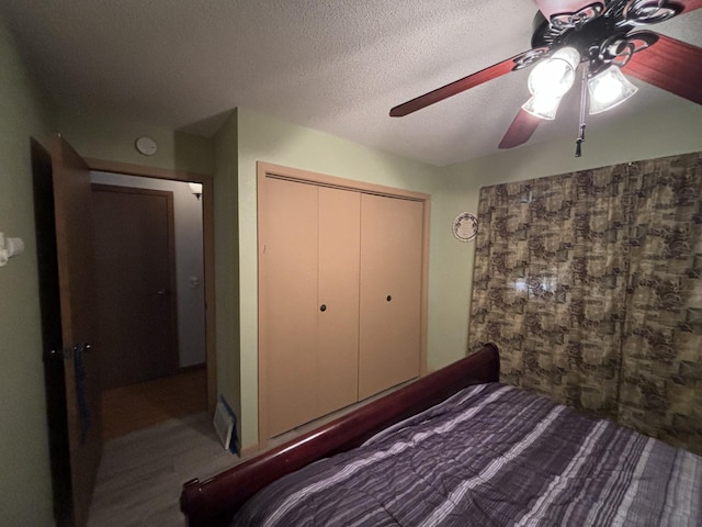 unfurnished bedroom with a closet, ceiling fan, hardwood / wood-style flooring, and a textured ceiling