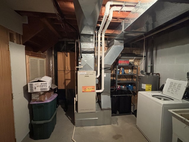 basement with water heater, heating unit, and washer / clothes dryer