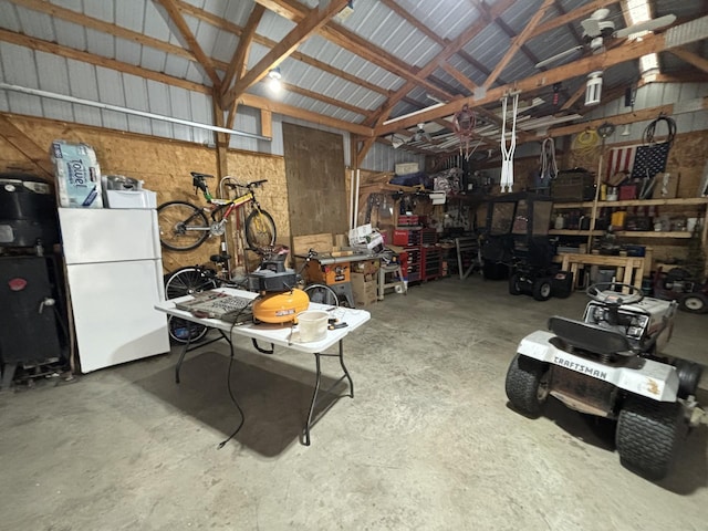 garage with a workshop area and white refrigerator