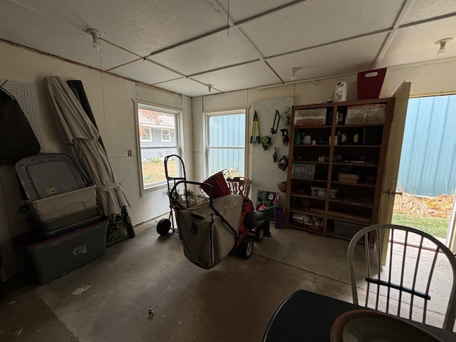 misc room featuring a drop ceiling and concrete floors