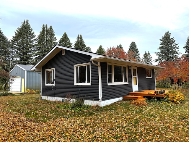 exterior space featuring a lawn, an outbuilding, and a garage