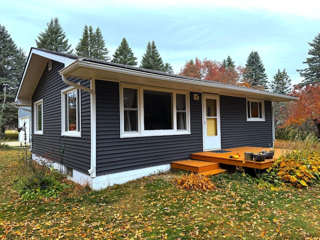 view of front of property featuring a deck and a front lawn