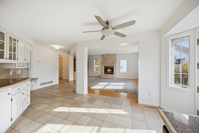 kitchen featuring white cabinetry, light tile patterned floors, backsplash, and a wealth of natural light