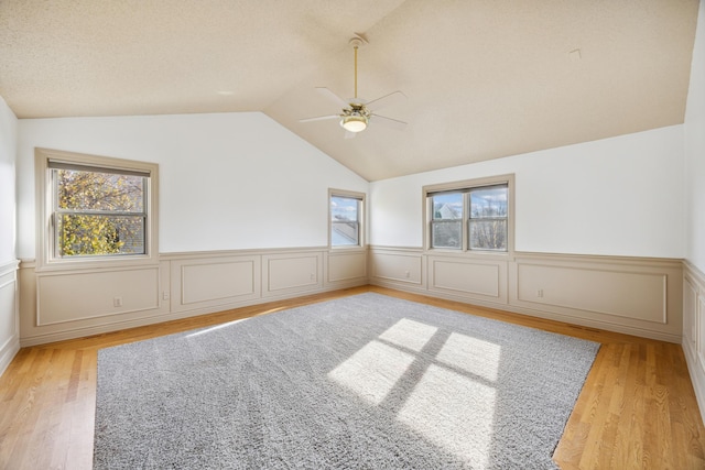 spare room featuring ceiling fan, light wood-type flooring, and vaulted ceiling