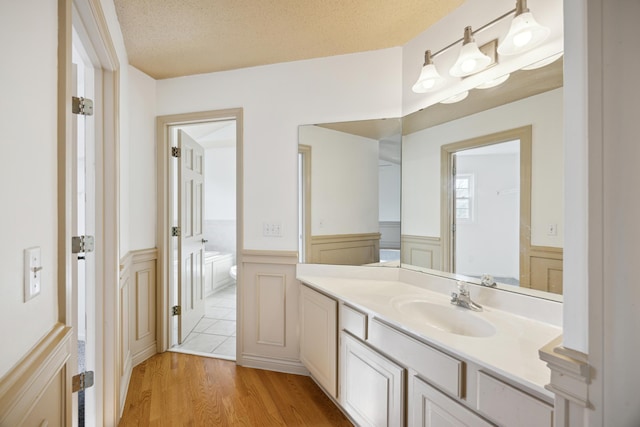 bathroom featuring vanity, hardwood / wood-style floors, and a textured ceiling