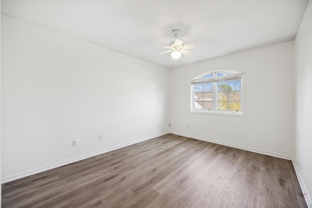 empty room featuring dark hardwood / wood-style floors, a textured ceiling, and ceiling fan