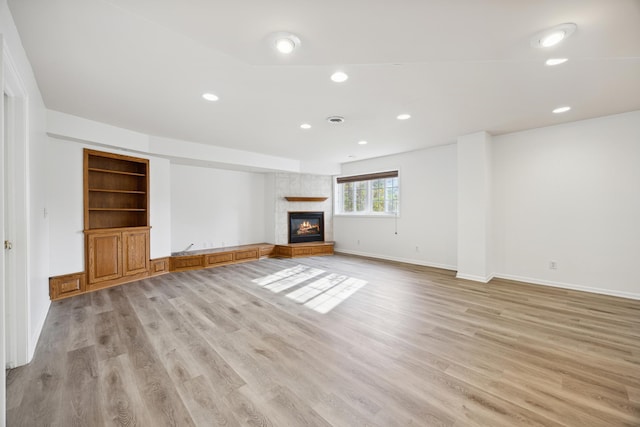 unfurnished living room featuring a fireplace and light wood-type flooring