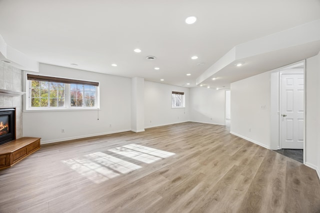 unfurnished living room featuring light hardwood / wood-style floors and a fireplace