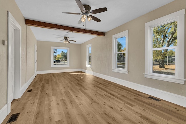 unfurnished living room with beam ceiling, light hardwood / wood-style flooring, and plenty of natural light