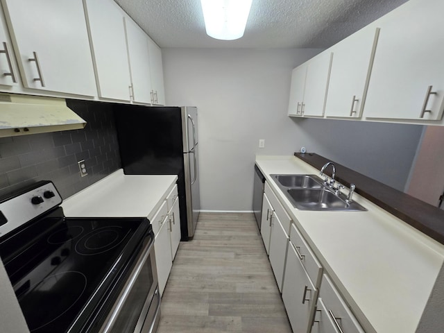 kitchen with stainless steel appliances, ventilation hood, sink, white cabinetry, and light hardwood / wood-style floors