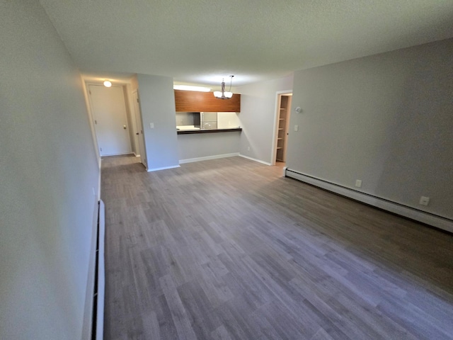 unfurnished living room with a textured ceiling, a baseboard radiator, and light wood-type flooring