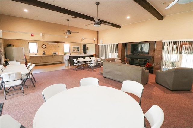 dining room with beamed ceiling, carpet flooring, and ceiling fan