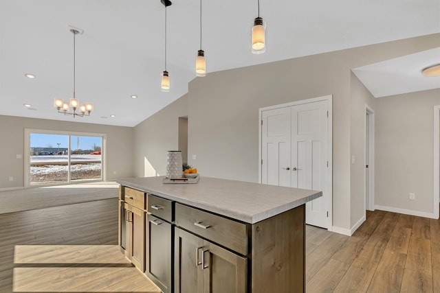 kitchen featuring lofted ceiling, a center island, light hardwood / wood-style flooring, and hanging light fixtures