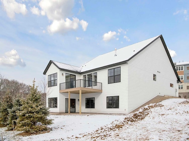 snow covered property with a balcony